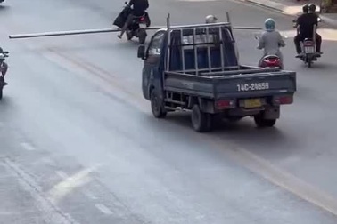 Người đàn ông đi xe máy chở hàng cồng kềnh, chiếm hết cả làn đường