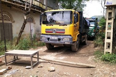 Bức xúc xe chở đất gây bụi, dân mang bàn ghế chắn đường