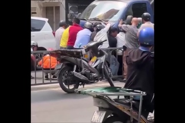 Người dân TPHCM chung sức nâng xe tải cứu người bị nạn
