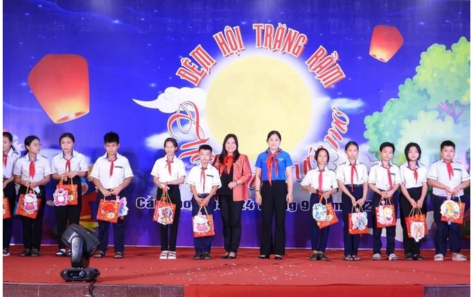 Bà Trần Thị Xuân Mai - GĐ Sở Lao động - Thương binh và Xã hội TP.Cần Thơ (áo đỏ) tặng quà cho trẻ em có hoàn cảnh khó khăn.