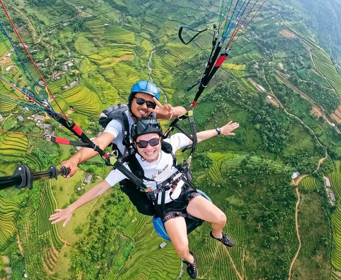 Du khách đăng ký bay dù lượn ngắm cảnh đẹp Ruộng bậc thang Mù Cang Chải vào mùa lúa chín.