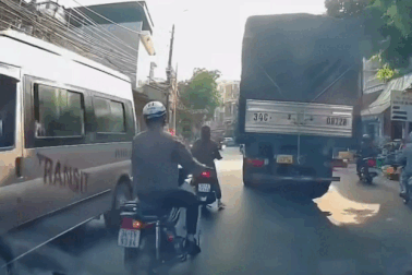 Phanh gấp, người phụ nữ đi xe máy ngã lao vào bánh xe tải