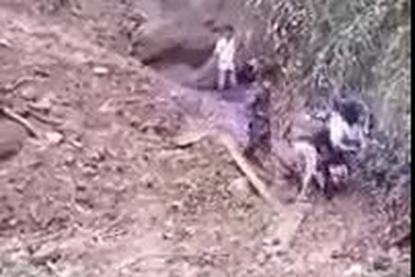 Các thầy giáo và người dân kéo đẩy xe máy qua đoạn đường sạt lở