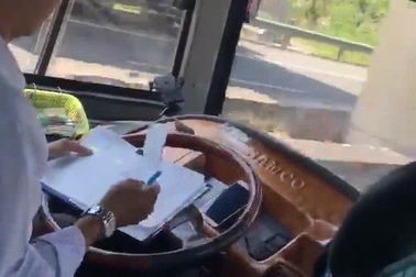 Rợn người khoảnh khắc tài xế xe khách vừa điều khiển xe vừa ghi chép