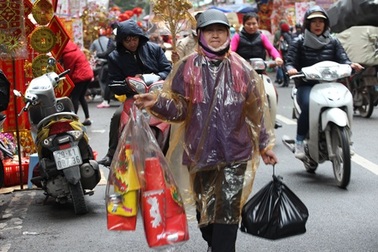 Tranh thủ ngày nghỉ, người dân đội mưa đi sắm đồ cho ông Táo