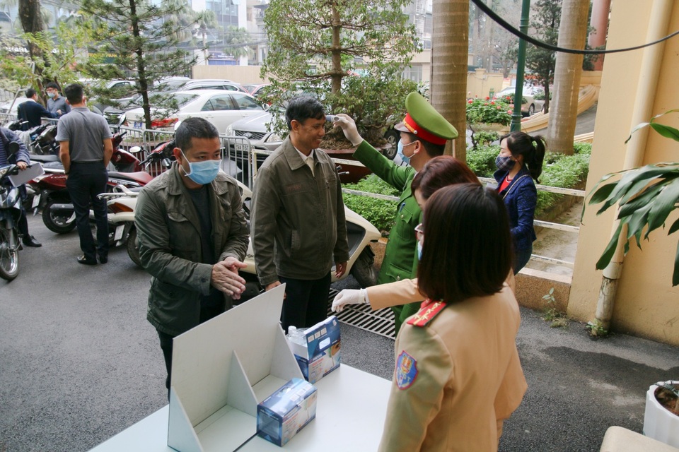 Công an Hà Nội đo thân nhiệt, phát khẩu trang cho công dân đến làm việc - 6