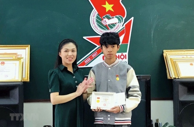 Em Nguyễn Trung Hiếu nhận Huy hiệu Tuổi trẻ dũng cảm. Ảnh TTXVN