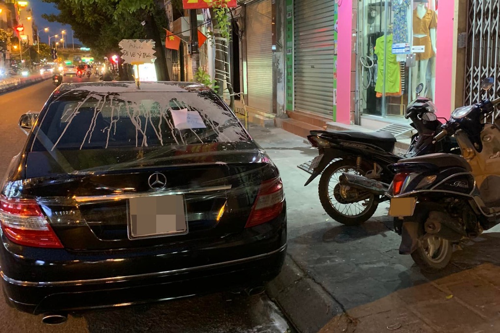 Ô tô đỗ trước cửa hàng bị người phụ nữ dán băng dính và vẩy bột trắng xe - 2 Ô tô đỗ trước cửa hàng bị người phụ nữ dán băng dính và vẩy bột trắng xe - 2