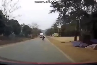 Xe máy kẹp ba, không đội mũ bảo hiểm, lạng lách trên đường lao thẳng vào đầu xe tải