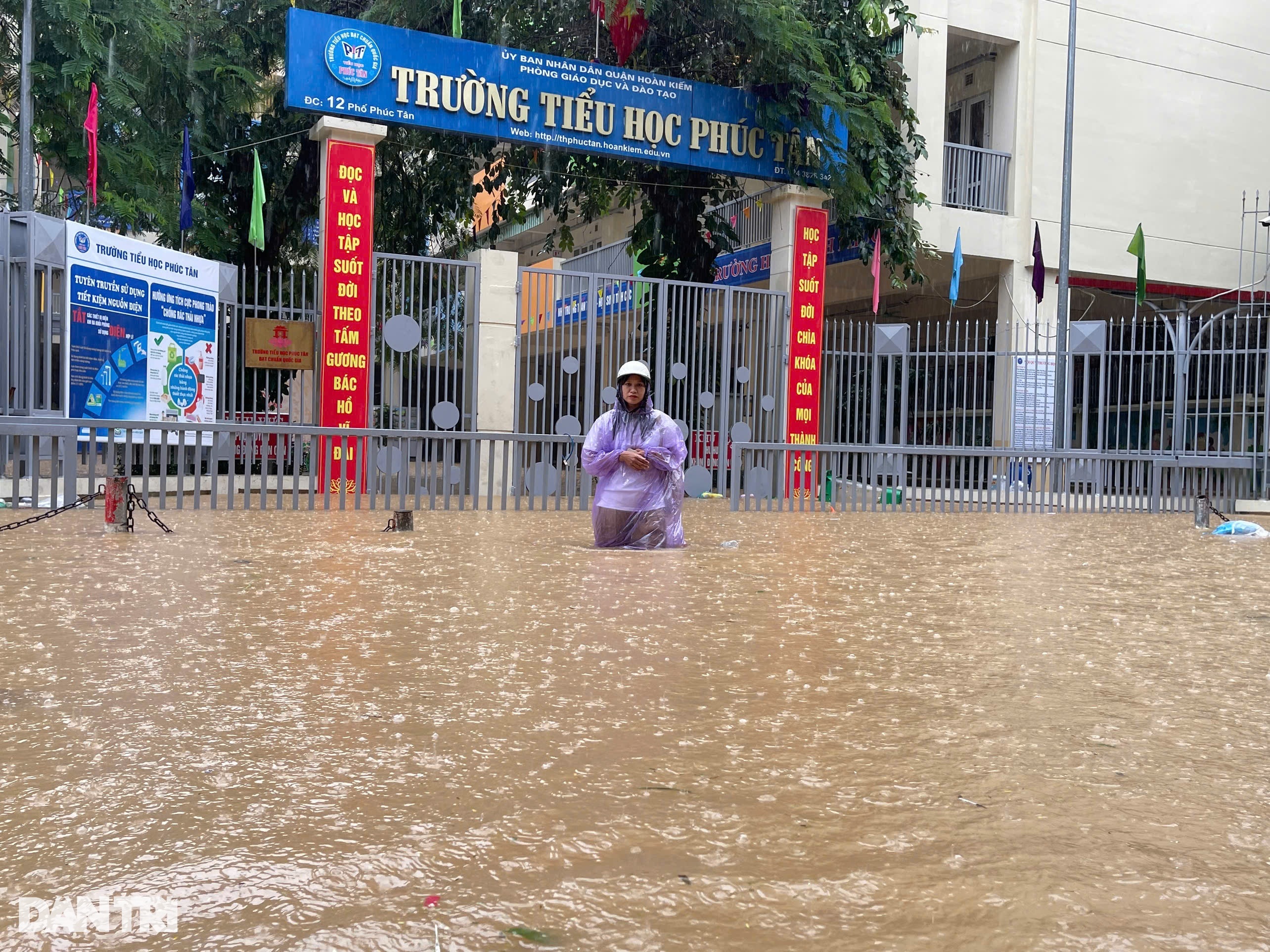 Nước ngập sâu khu vực trước cổng trường, khiến việc đi lại qua đây rất khó khăn (Ảnh: Mỹ Hà).