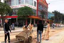 CSGT cùng người dân dọn đất, đá rơi vãi trên đường