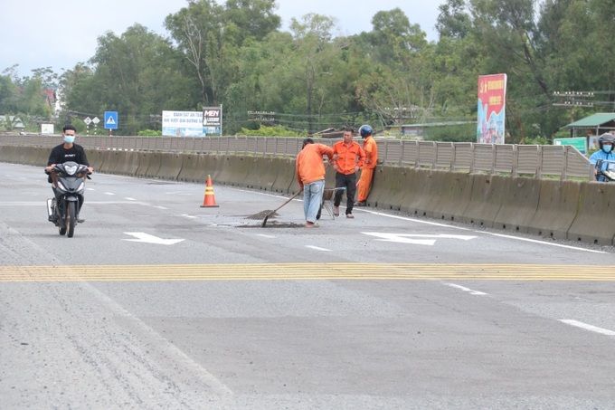 Sau khi dùng xẻng cào bằng mớ bê tông nhựa vừa đổ từ chiếc xe rùa xuống