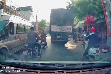 Phanh gấp, người phụ nữ đi xe máy ngã lao vào bánh xe tải