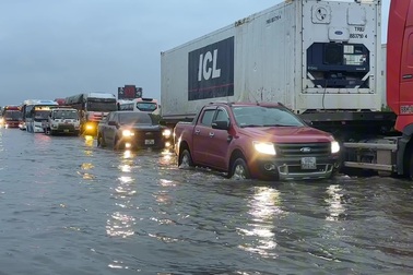 Ô tô xếp hàng dài nối đuôi nhau đi qua điểm ngập trên cao tốc