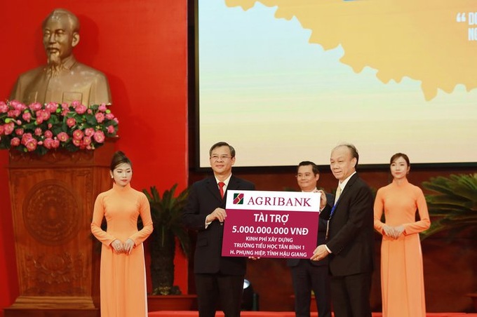 Ông Nguyễn Minh Trí, Thành viên HĐTV Agribank (bên phải) trao tiền tài trợ.
