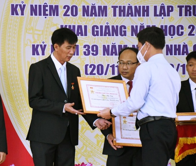 Ông Ngô Văn Trọng trao bằng khen của Bộ LĐ-TB&XH cho lãnh đạo nhà trường
