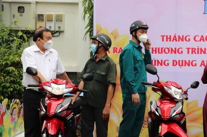 Ông Lê Minh Tấn, Giám đốc Sở LĐ-TB&XH TP.HCM trao phương tiện lammf ăn cho người dân khó khăn.