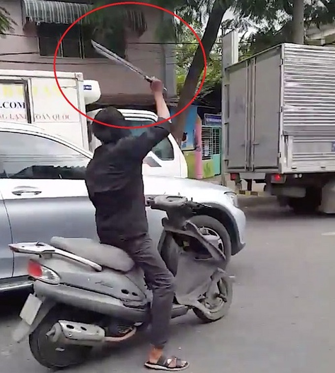 Thanh niên cầm mã tấu chém hàng loạt kính chiếu hậu của ô tô trên đường (ảnh cắt từ clip)