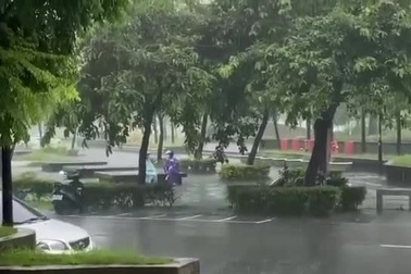 Hai người phụ nữ ngồi dưới cơn mưa tầm tã để "tám chuyện"