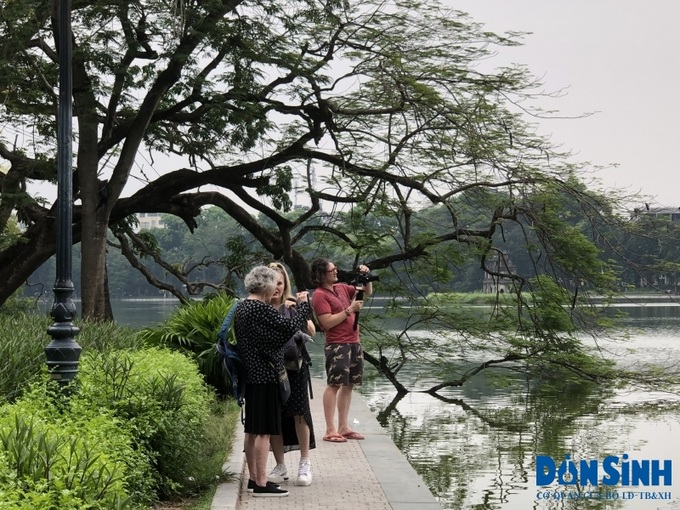 Du khách quốc tế quay phim, chụp ảnh bên Hồ Gươm (Hà Nội).