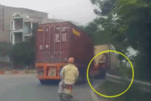 Người đi xe máy thoát chết "diệu kỳ" dưới gầm xe container
