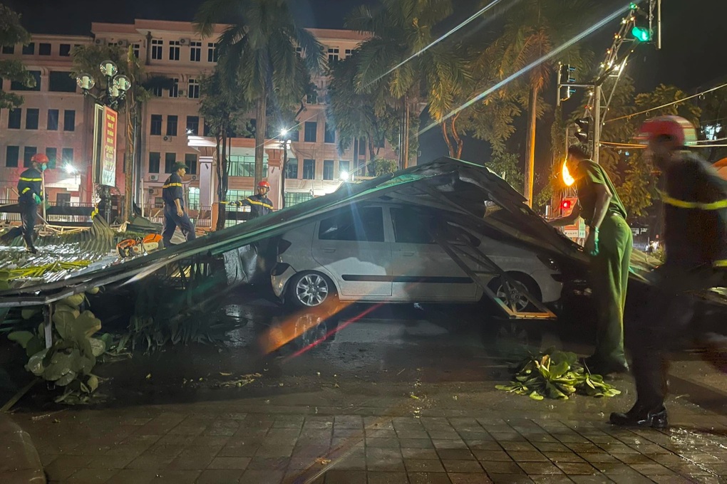 Biển quảng cáo, mái tôn đè ô tô, dây điện vắt ngang đường sau cơn dông lốc - 3