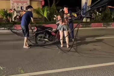 Cô gái đi xe máy vướng vào đống dây cáp rơi giữa đường