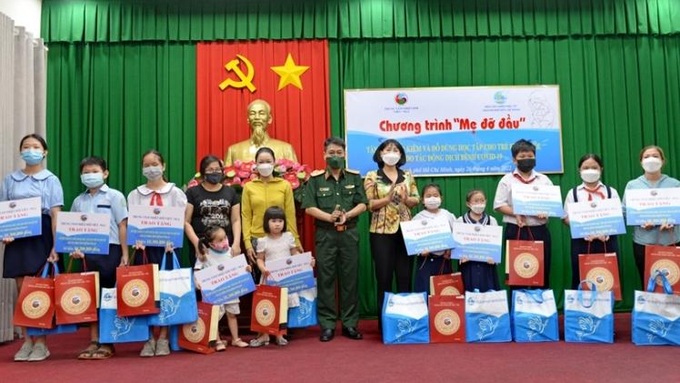 Các trẻ em mồ côi nhận quà và đồ dùng học tập tại buổi lễ. Ảnh qdnd.vn