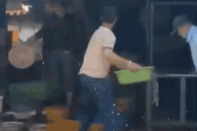 Người phụ nữ và nhóm nam giới liên tục hất chậu cá vào nhau giữa đường