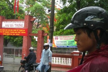 Phụ huynh dầm  mưa chờ con ngoài phòng thi