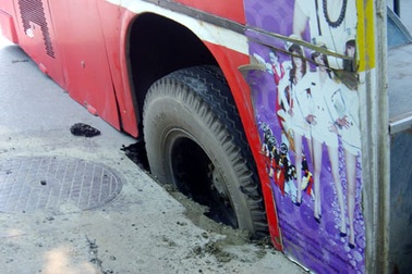 Xe buýt “sập bẫy” hố ga