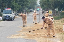 CSGT mượn chổi dọn cát sỏi rơi vãi trên đường