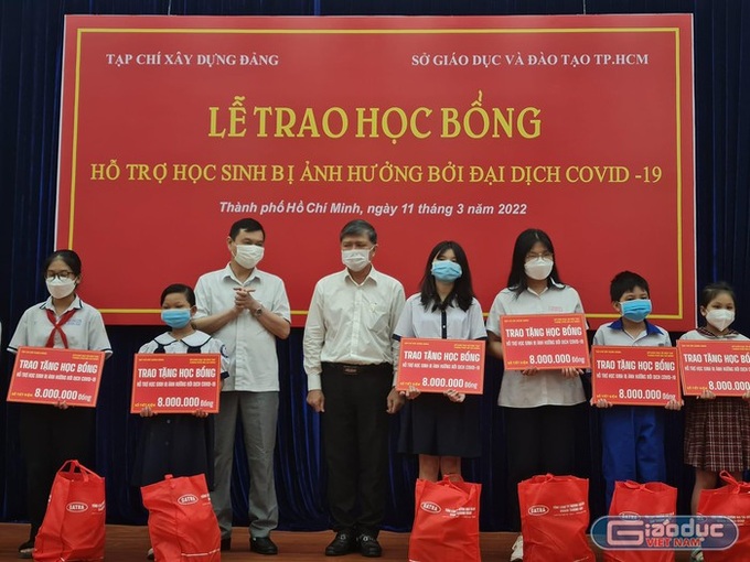 Ông Nguyễn Văn Hiếu (đứng thứ 4, trái sang) trao tặng học bổng cho các em học sinh