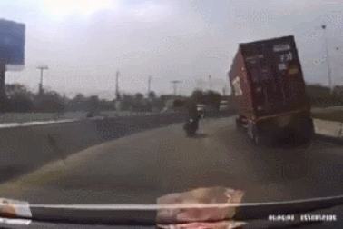 Xe công-ten-nơ đổ kềnh khi vào cua, suýt đè bẹp người đi xe máy