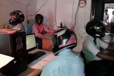 Công chức văn phòng vừa làm việc vừa đội mũ bảo hiểm