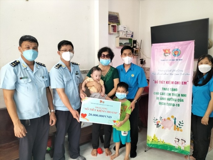 Trao sổ tiết kiệm cho em hỗ trợ trẻ mồ côi do COVID-19.