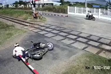 Vừa chạy xe máy vừa nghe điện thoại, còn liều lĩnh vượt qua chắn đường sắt