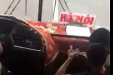 Tài xế "soi serie" ăn tiền với phụ xe khi đang lái xe chở khách chạy trên đường, gây mất an toàn giao thông.