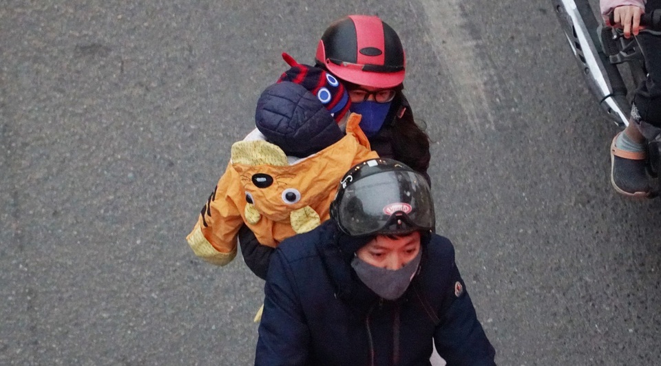 Trẻ em được bố mẹ bọc kín mít đi đường trong tiết trời lạnh giá ở Hà Nội - 10