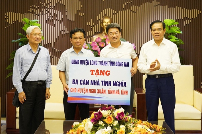 Chủ tịch UBND tỉnh chứng kiến huyện Long Thành tặng biểu trưng 3 nhà tình nghiã cho huyện Nghi Xuân.