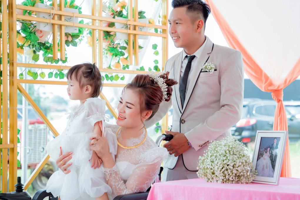 Người mẹ trẻ ôm con gái vào lễ đường bằng xe lăn - 1 Người mẹ trẻ ôm con gái vào lễ đường bằng xe lăn - 1