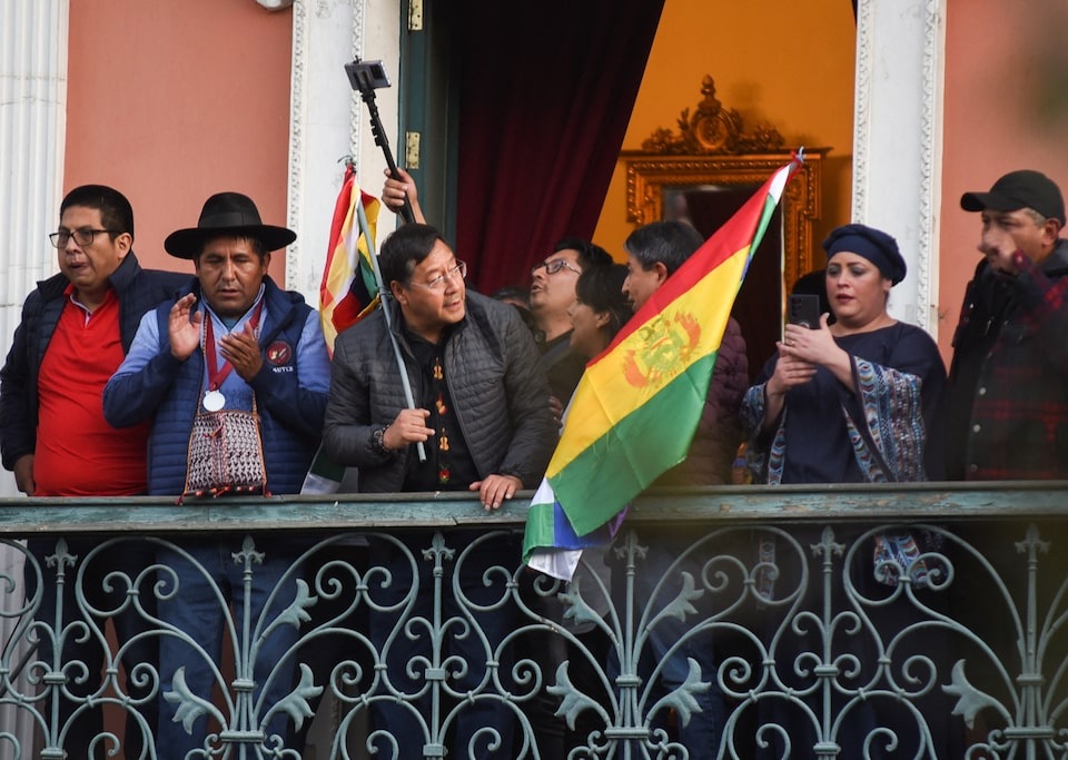 Từ dinh tổng thống, ông Arce phát biểu: "Hôm nay đất nước đang phải đối mặt với một âm mưu đảo chính. Tôi kêu gọi người dân Bolivia tập hợp ngày hôm nay. Chúng tôi cần người dân Bolivia tổ chức và vận động chống lại cuộc đảo chính". Trong ảnh: Tổng thống Arce (thứ 3 từ trái sang) cầm cờ đứng ở dinh tổng thống khi đảo chính diễn ra (Ảnh: Reuters).