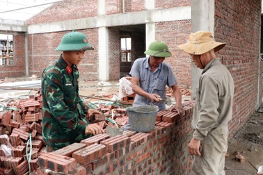 Bộ đội làm thợ xây, uốn sắt trên công trình trường liên cấp