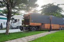 Xe đầu kéo chở 6 ô tô húc sập tường rào công ty ở TPHCM