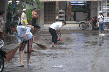 Người dân TPHCM xuống đường dọn rác, bùn đất sau cơn mưa lớn
