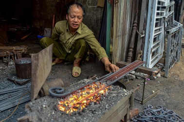 Thợ rèn "múa lửa" đe búa bên lò lửa ngày siêu nóng