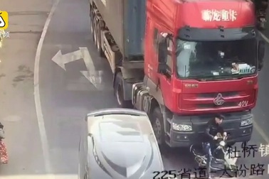 Người đi xe đạp điện thoát chết thần kỳ dưới gầm xe tải