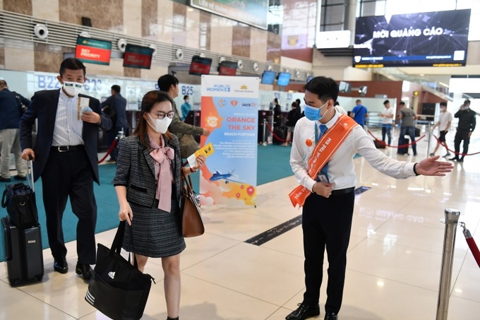 Ảnh 2 - Hành khách được chào đón đặc biệt tại sân bay bởi các nhân viên mặt đất phục vụ chuyến bay đều đeo ruy băng, hoa cài màu cam