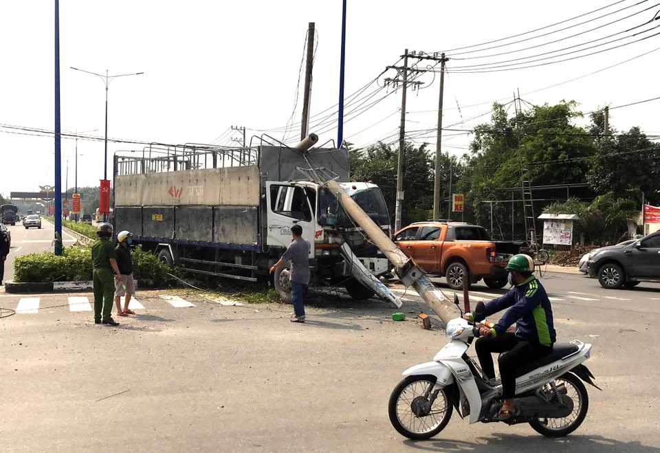 Xe tải lao lên dải phân cách tông gãy trụ điện, 3 người thoát nạn - 1