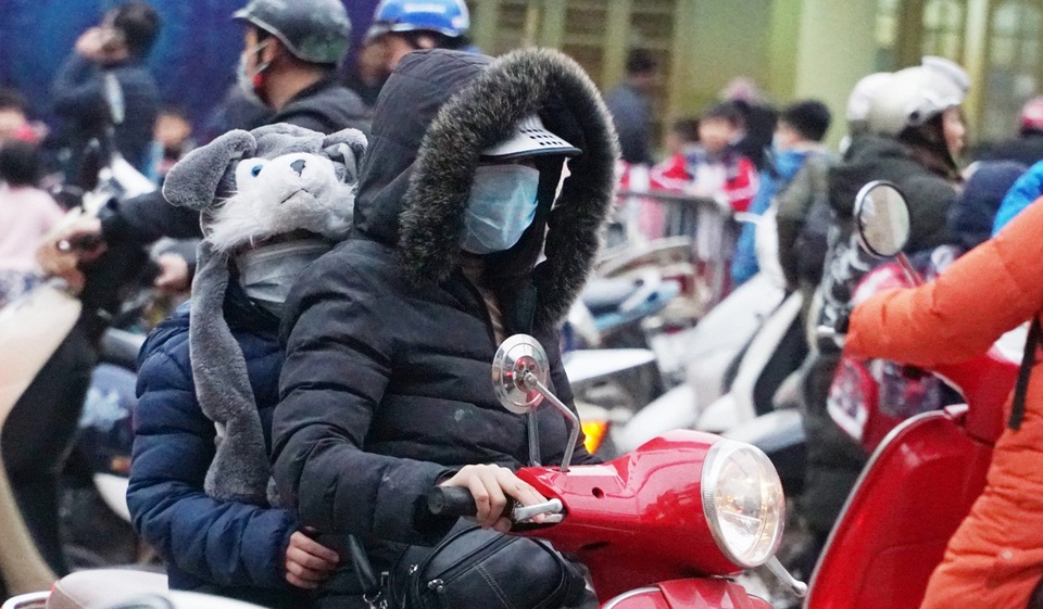 Trẻ em được bố mẹ bọc kín mít đi đường trong tiết trời lạnh giá ở Hà Nội - 7